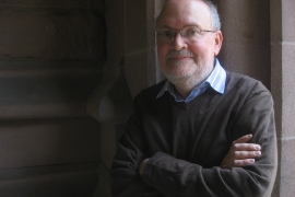 Leonard Barkan with arms crossed in an archway